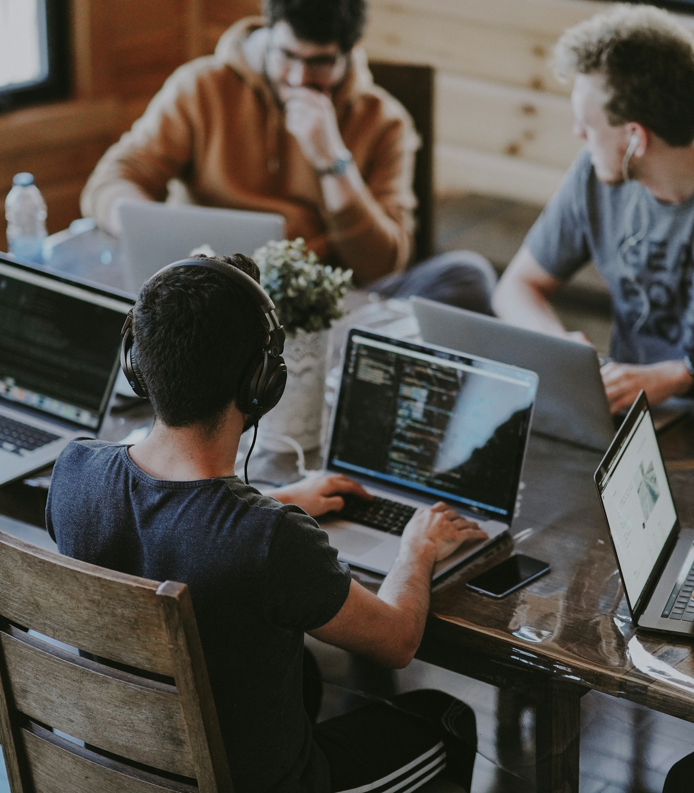 Colleagues working together around a table with laptops